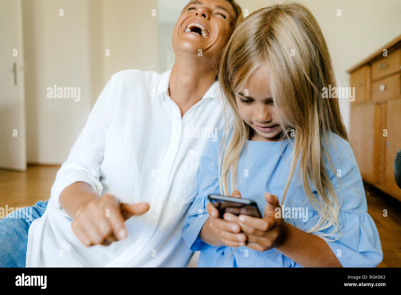 Lachen, Mutter und Tochter am Smartphone suchen Stockfoto