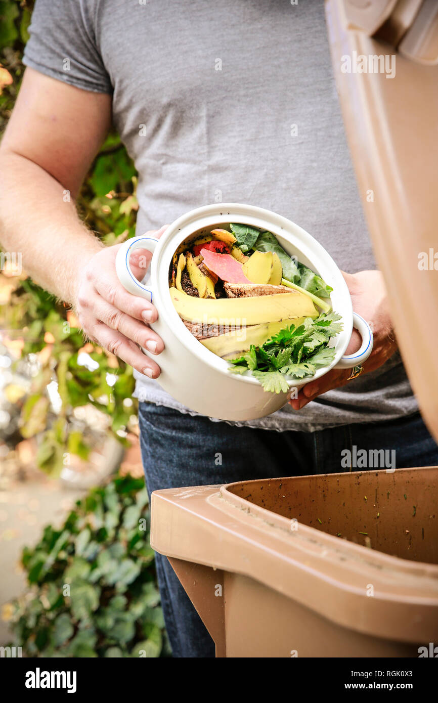 Reifer Mann werfen Küche Botschaften in bio-waste Container Stockfoto