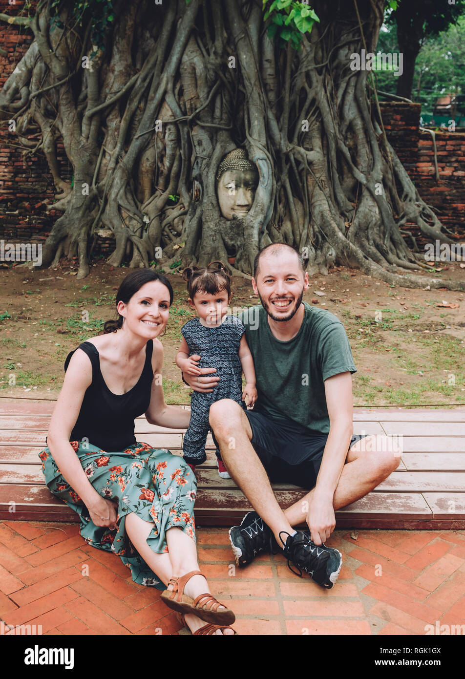 Thailand, Ayutthaya, Portrait von lächelnden Familie Besuch der Buddha Kopf zwischen Baumwurzeln im Wat Mahathat Stockfoto