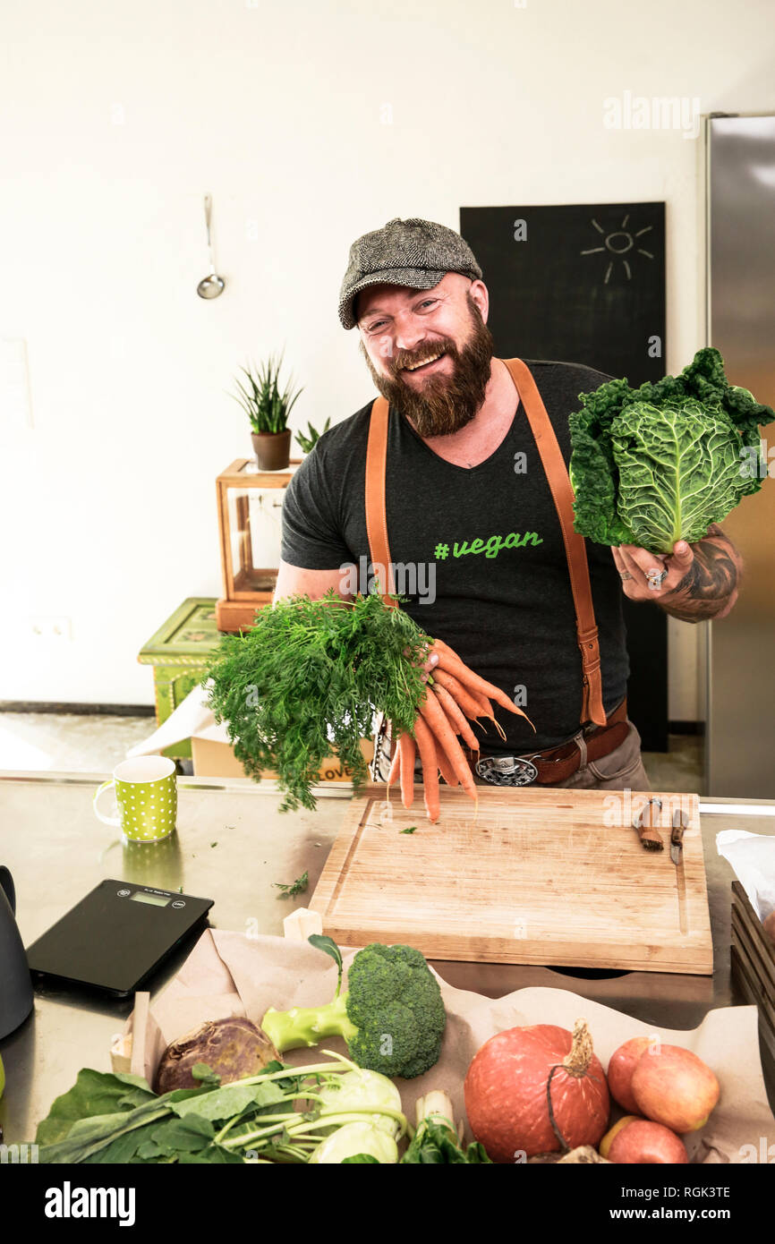 Vegan Mann sie Gemüse in seiner Küche Stockfoto