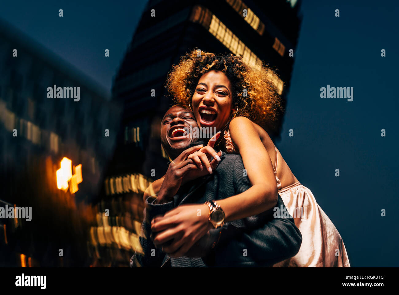 Lachen junges Paar, das Spaß haben in der Nacht in der Stadt Stockfoto