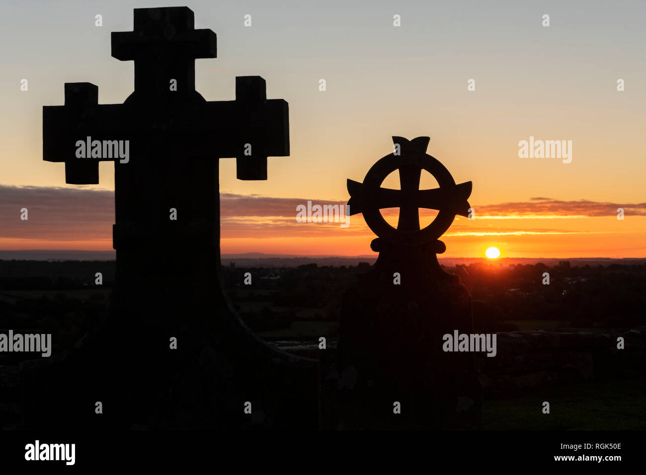 Vereinigtes Königreich, England, Old Sodbury, Kirche des Heiligen Johannes des Täufers, Friedhof, Kreuze bei Sonnenuntergang Stockfoto