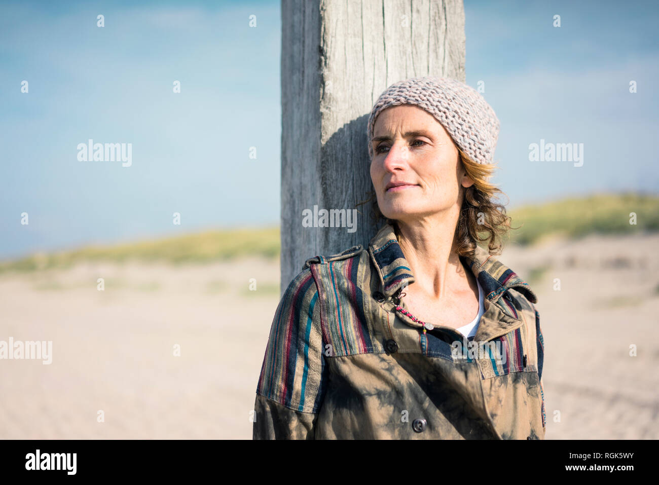 Frau mit Wollmütze schiefen auf Holz Pol Stockfoto