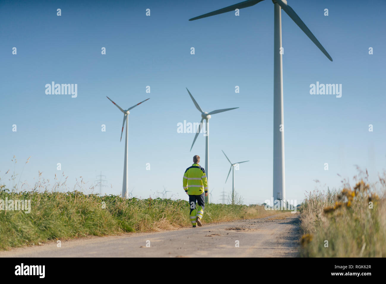 Ingenieur gehen auf Feld Pfad zu einem Windpark Stockfoto