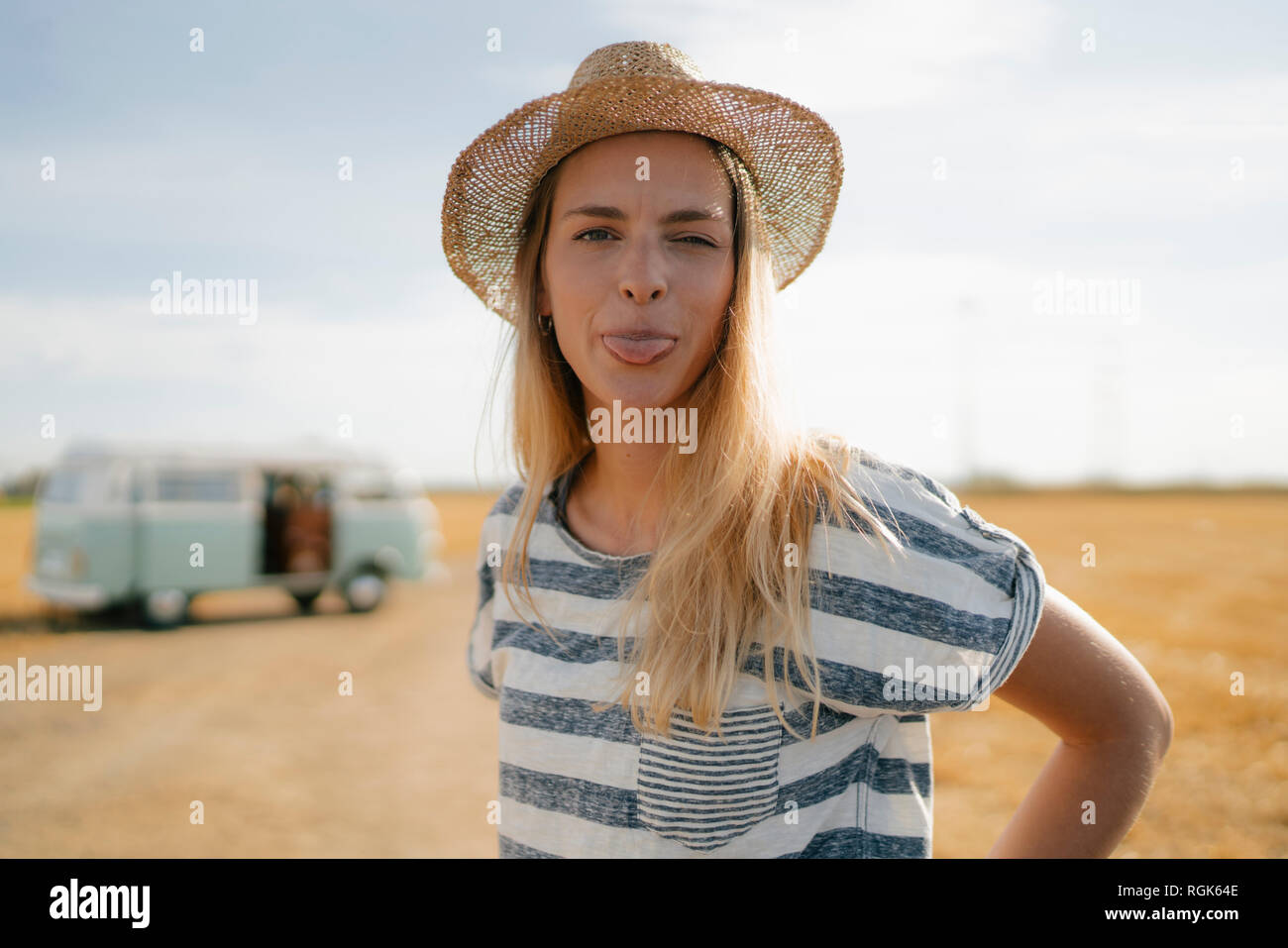 Porträt der jungen Frau an Wohnmobil in ländlichen Landschaft heraus Ihre Zunge Stockfoto