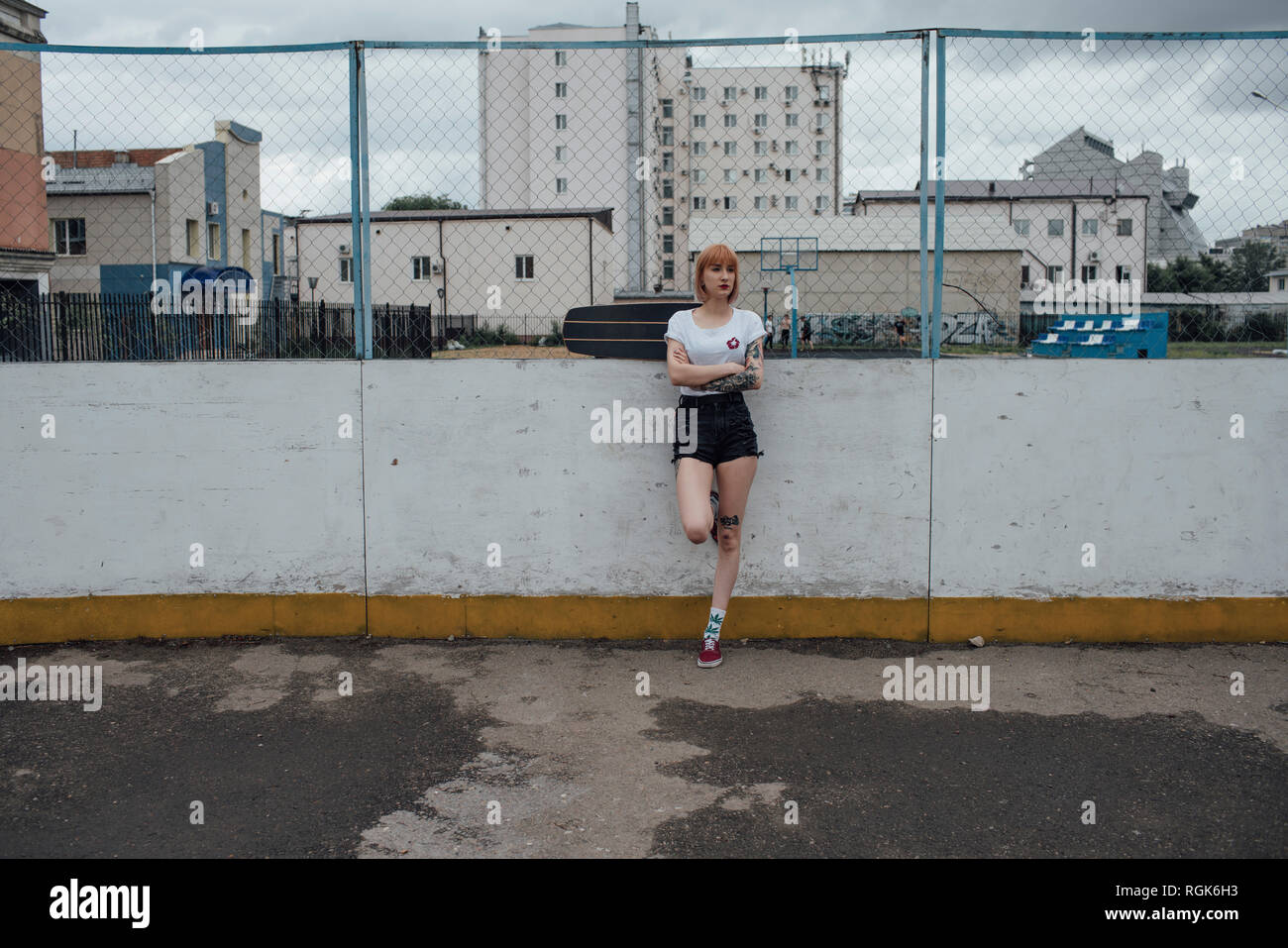 Cool junge Frau mit Carver skateboard stehend im Freien Stockfoto