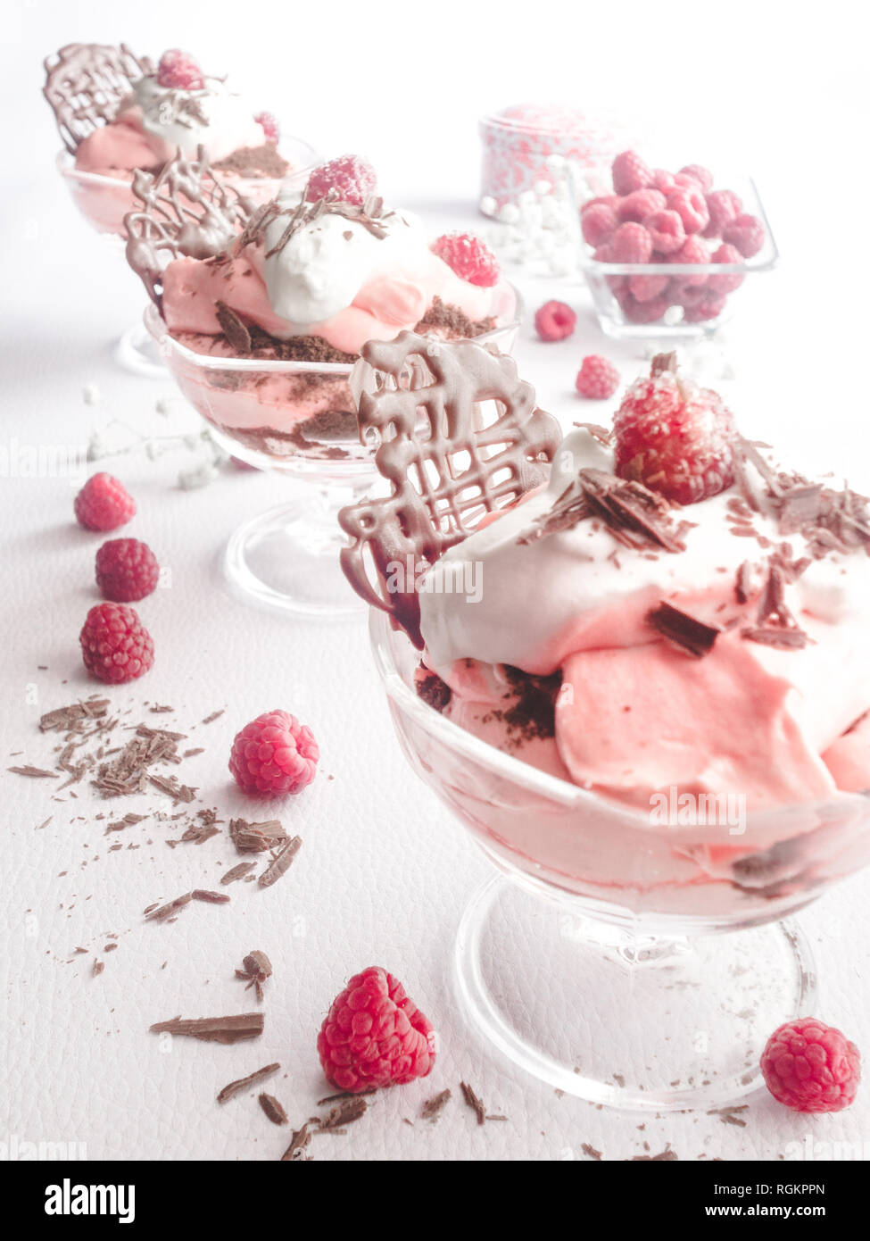 Drei Schokolade Himbeere Cloud Desserts in einer diagonalen Reihe mit Schlagsahne - Fotografie Stockfoto