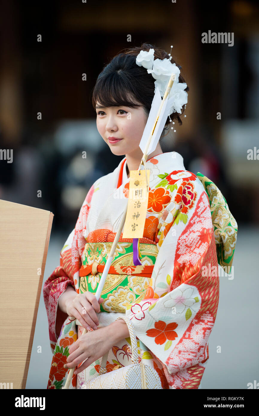 Junge Frau in einem Kimono mit einem HAMAYA am Tag der Erwachsenen am Meiji Schrein, Harajuku, Tokio, Japan Stockfoto