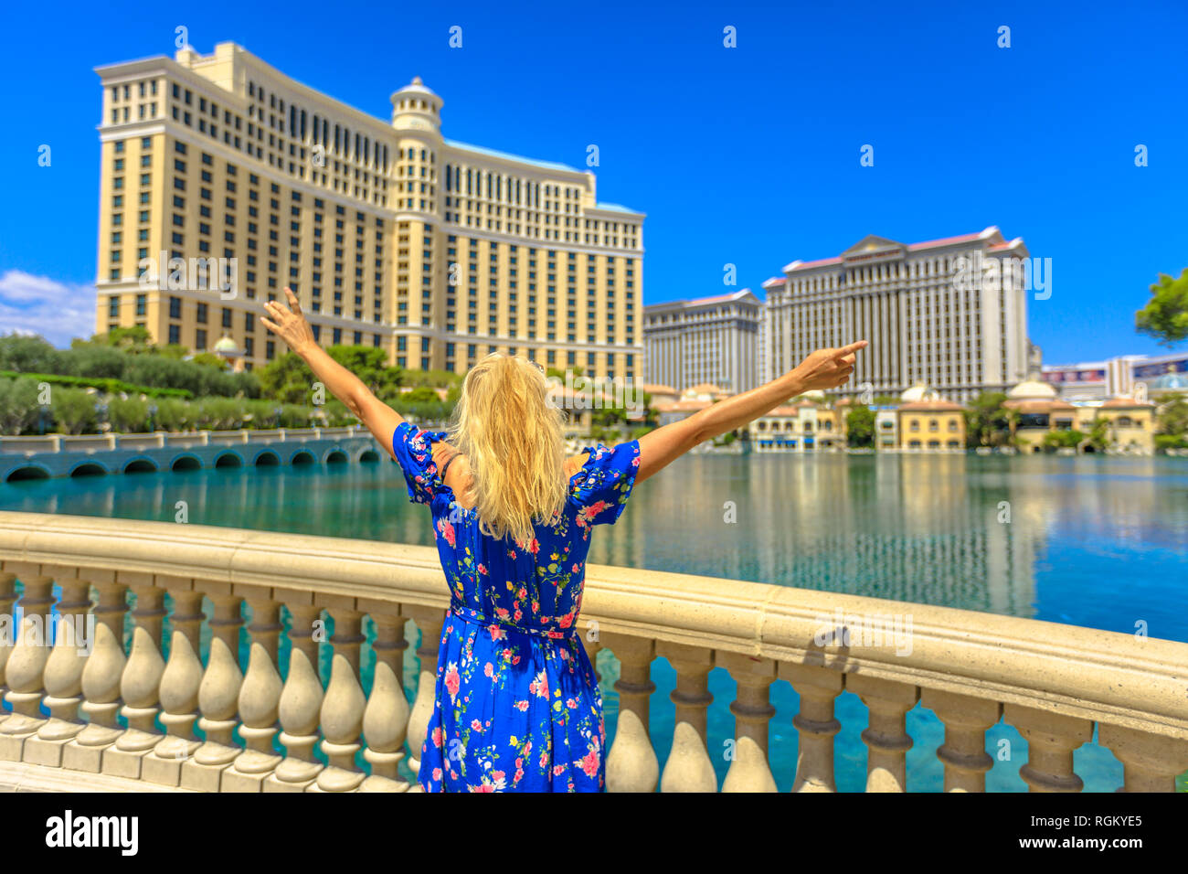Blond lifestyle Frau warten Fountain Show am grossen Teich mit klarem Wasser in Las Vegas Strip. Kaukasische touristische Spaß im Reisen im Freien Stockfoto
