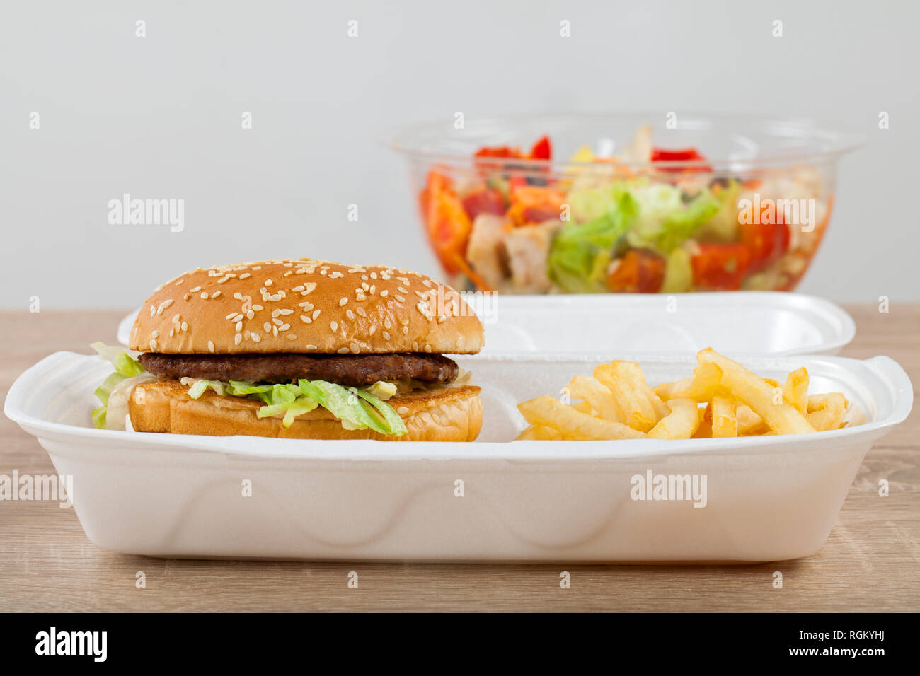 Leckere Cheeseburger Und Pommes Frites In Eine Box Aus Kunststoff Und Einem Frischen Salat Zu Gehen Fast Food Vs Gesundes Essen Stockfotografie Alamy