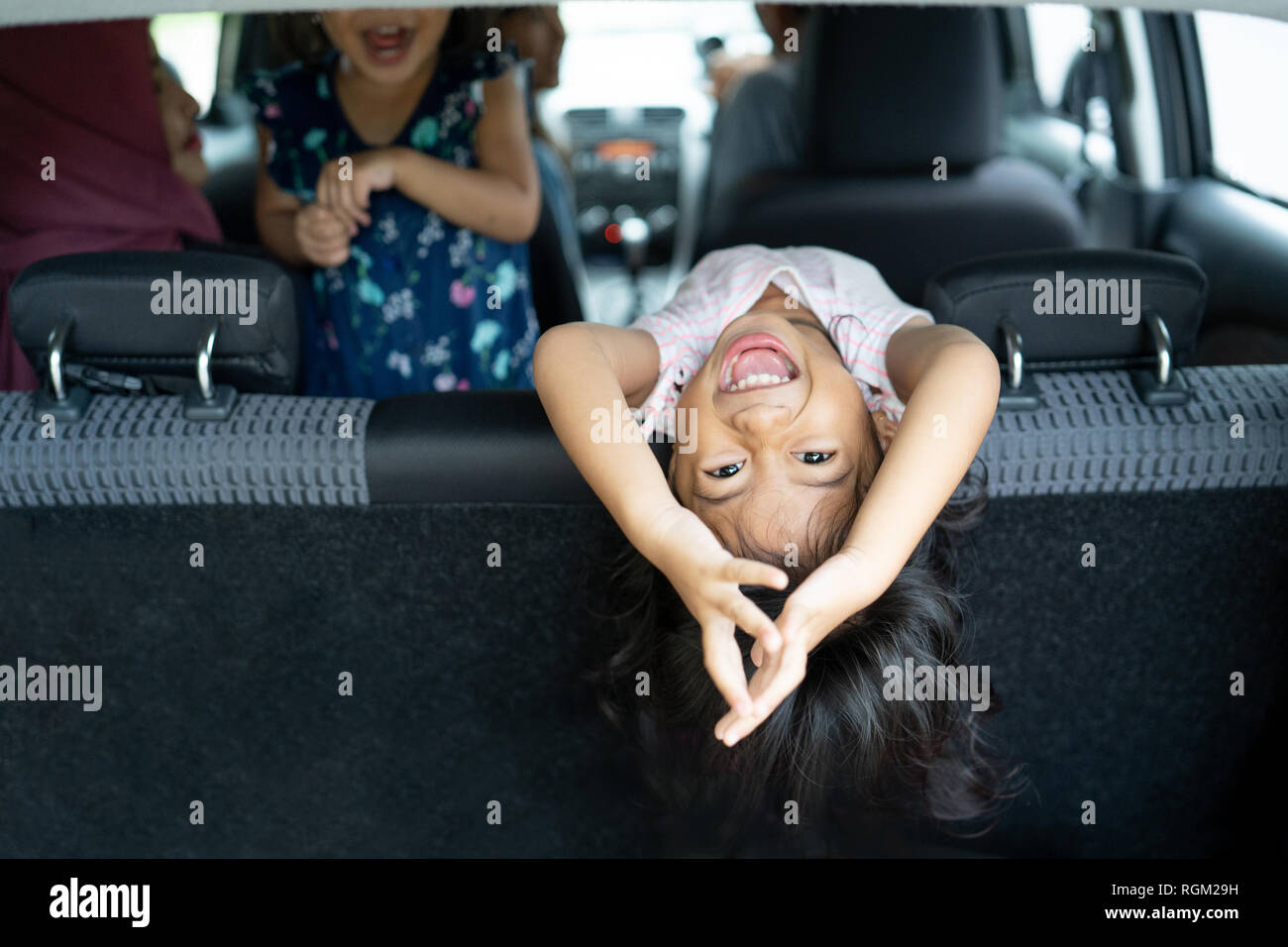 Glück der Tochter auf dem Sitz zurück Blick zurück auf das Gepäck mit Salto Position Stockfoto