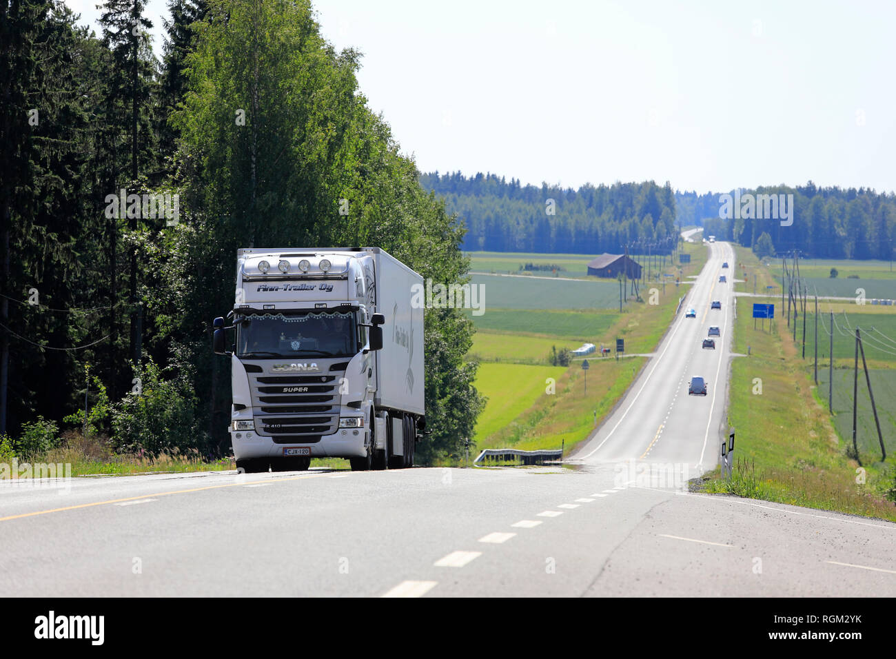 Jokioinen, Finnland - 14. Juli 2018: Weiße Fracht Stapler fährt bergauf in Highway Traffic durch ländliche Landschaft an einem sonnigen Tag der Sommer in Finnland. Stockfoto