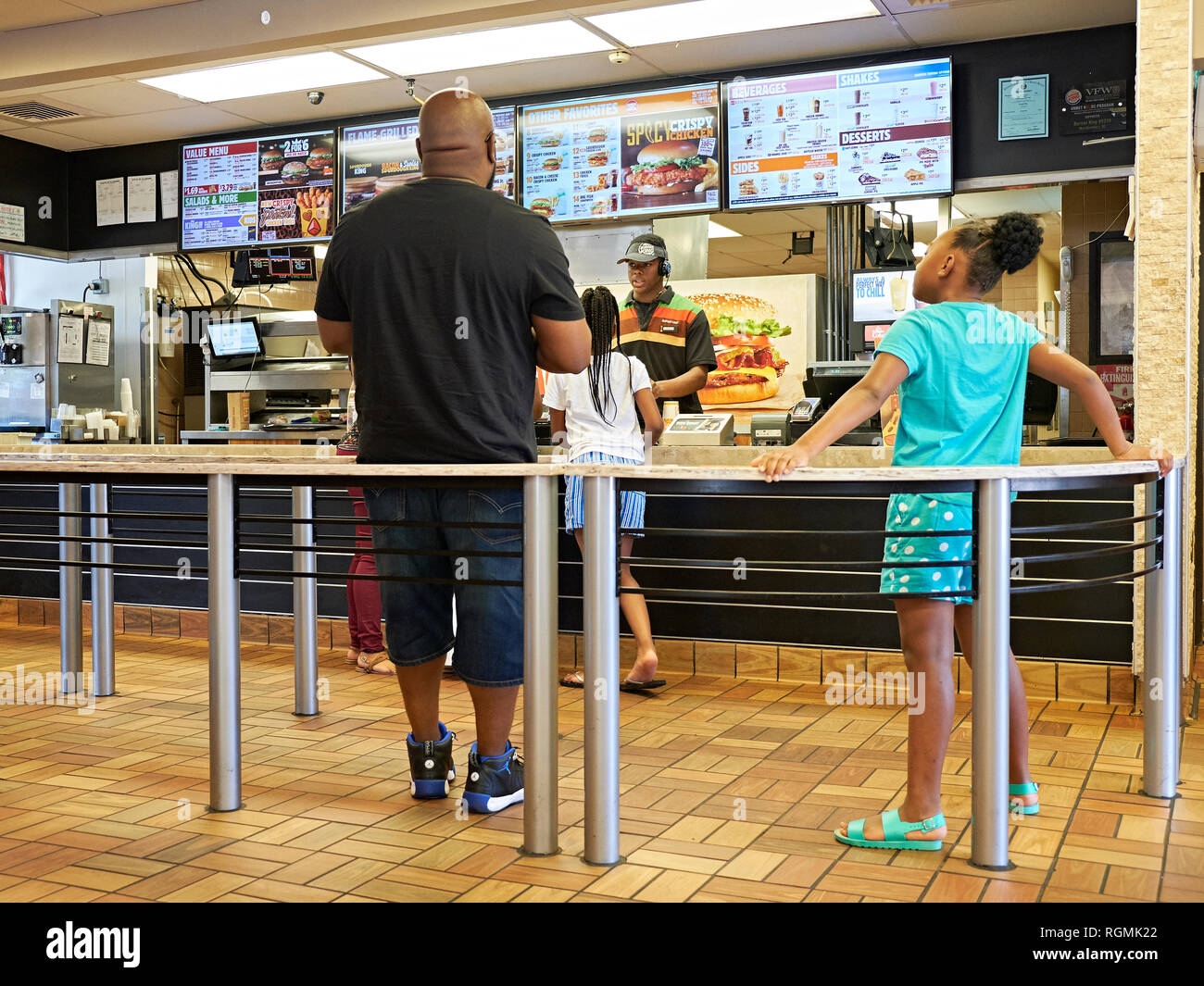 Vater oder Mann und junge Mädchen in Linie an einem Burger King fast food Restaurant in Montgomery Alabama, USA serviert wird. Stockfoto
