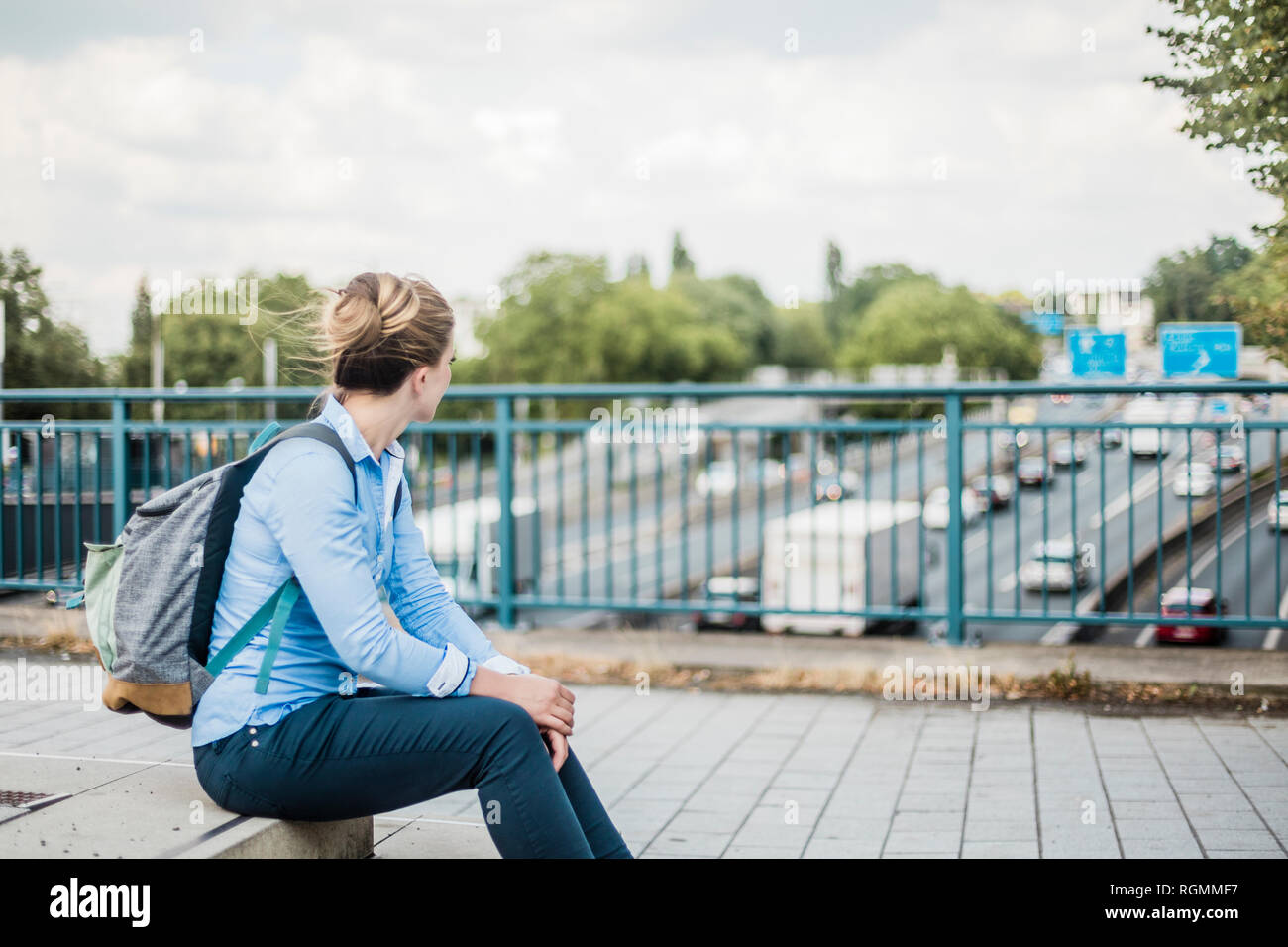 Frau mit Rucksack auf Autobahnbrücke Stockfoto