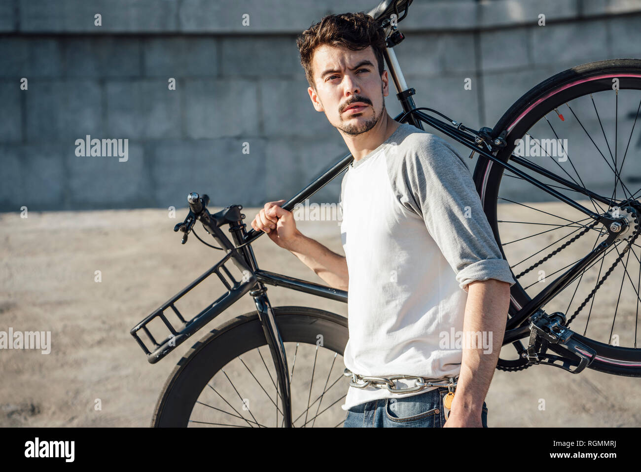 Junger Mann, der Pendler fixie Bike an der Betonwand Stockfoto