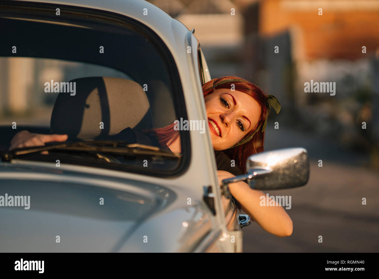 Junge Frau fahren Oldtimer im Sommer, lächelnd Stockfoto