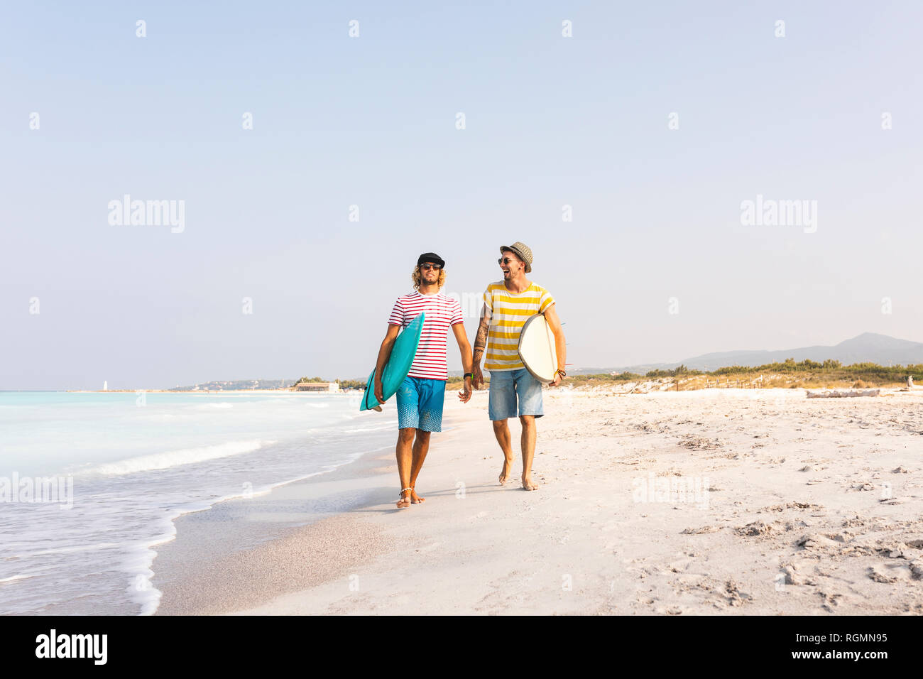 Freunde zu Fuß am Strand, Surfbretter Stockfoto