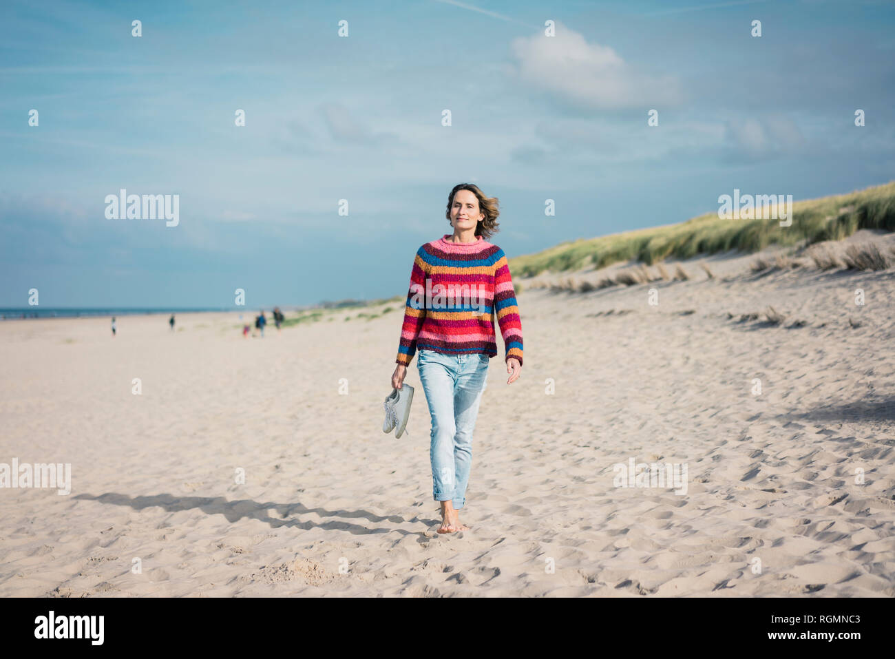 Reife Frau barfuß am Strand Stockfoto