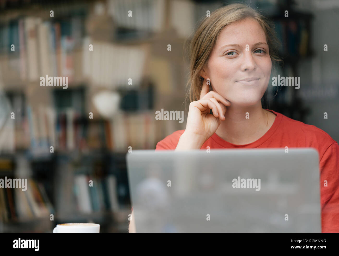 Portrait von lächelnden jungen Frau mit Laptop in einem Cafe Stockfoto