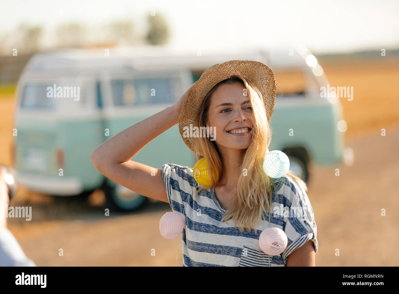 Glückliche junge Frau an Wohnmobil in ländlichen Landschaft Stockfoto