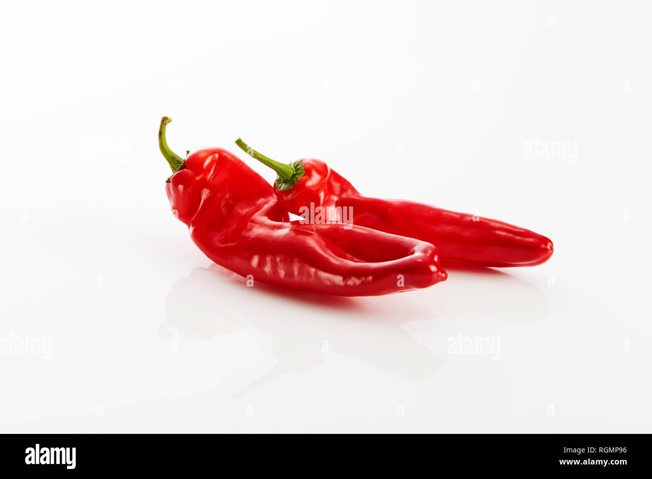 Zwei rote Spitzen Paprika vor weißem Hintergrund Stockfoto