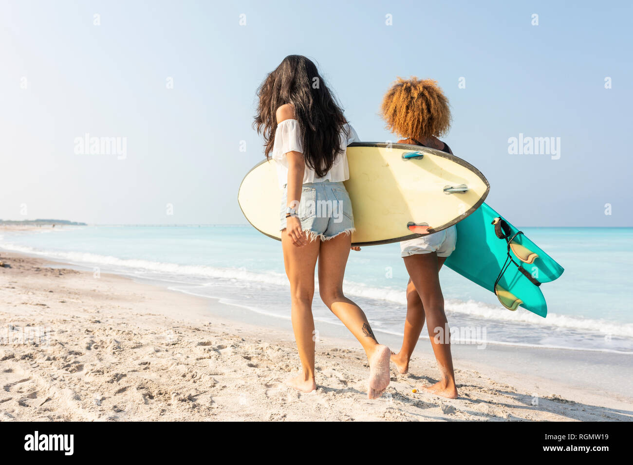 Freunde zu Fuß am Strand, Surfbretter Stockfoto