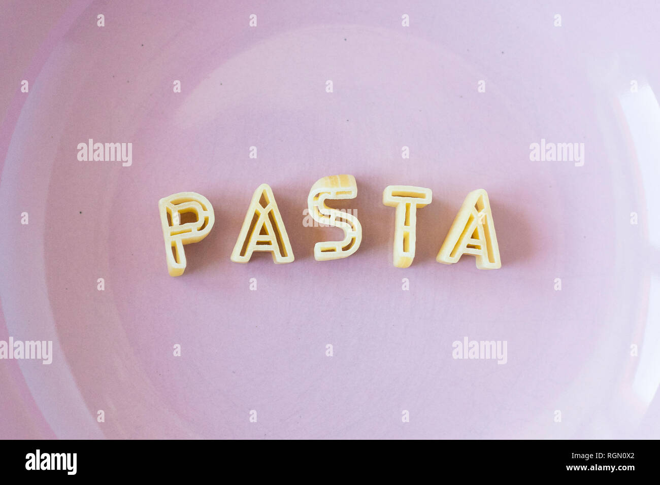 Das Wort "Pasta" mit echten pasta Buchstaben in einem rosa Schale. Close Up. Stockfoto
