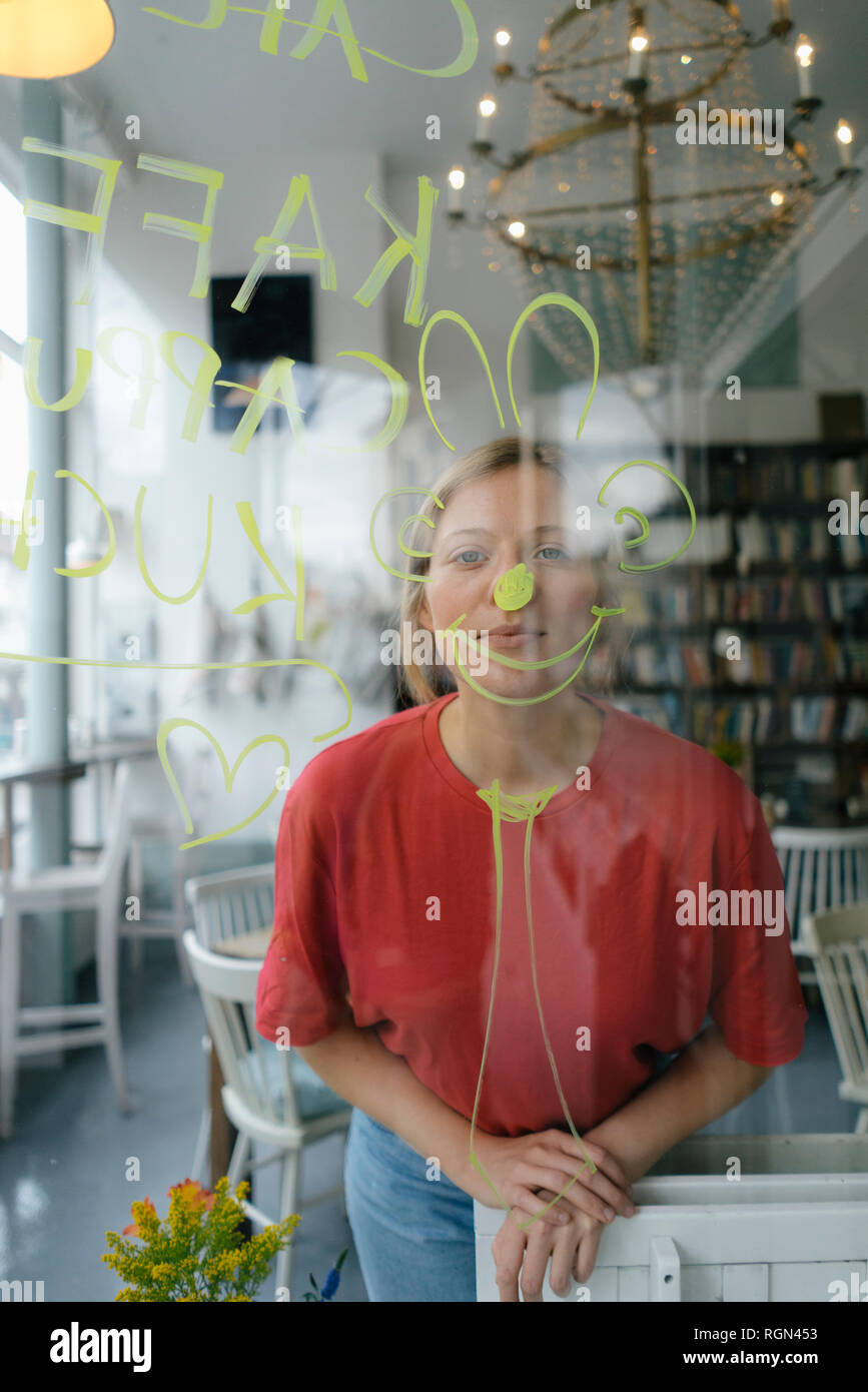 Porträt der jungen Frau hinter Fensterglas in einem Cafe posing Stockfoto