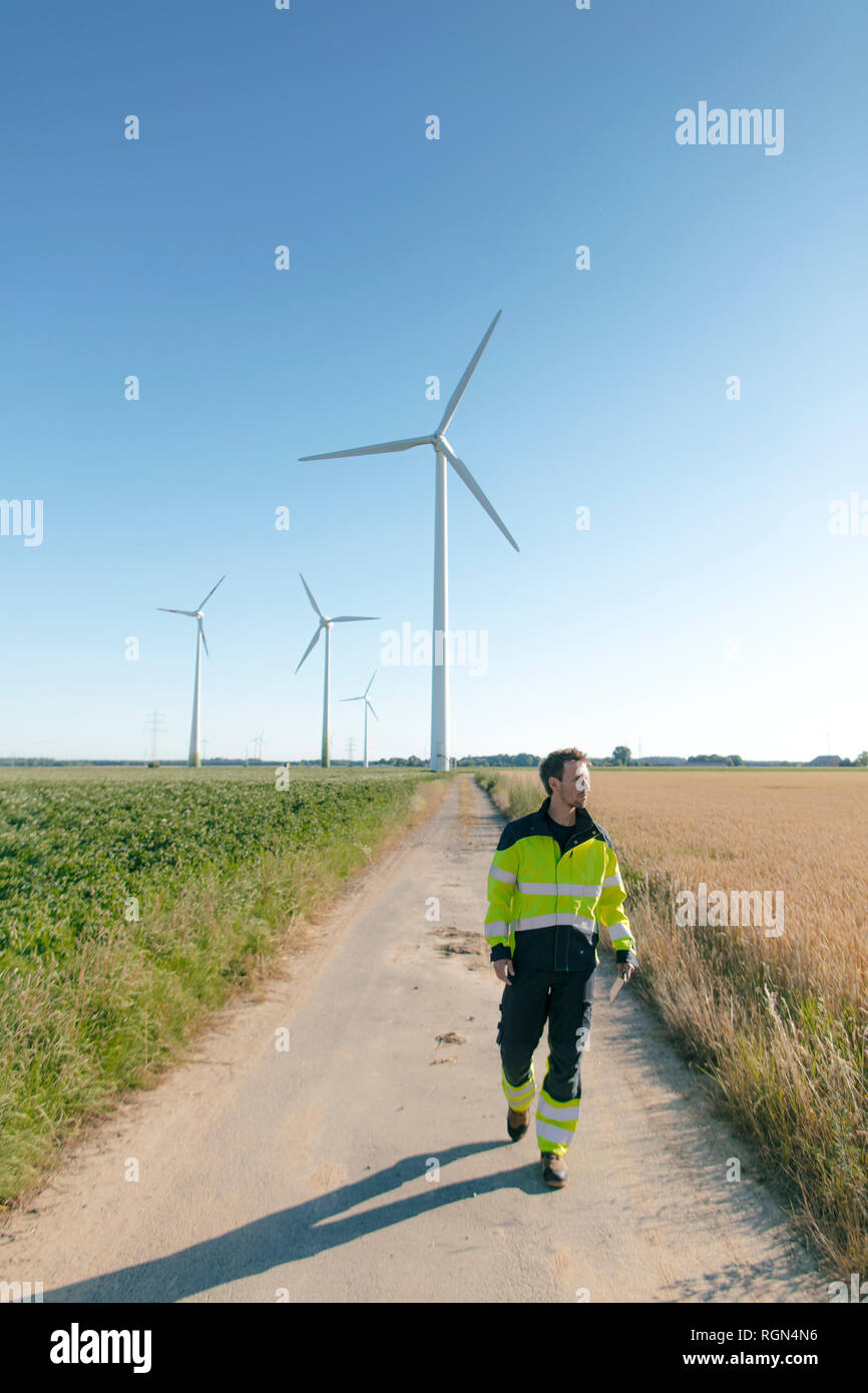 Ingenieur gehen auf Feld Pfad zu einem Windpark Stockfoto