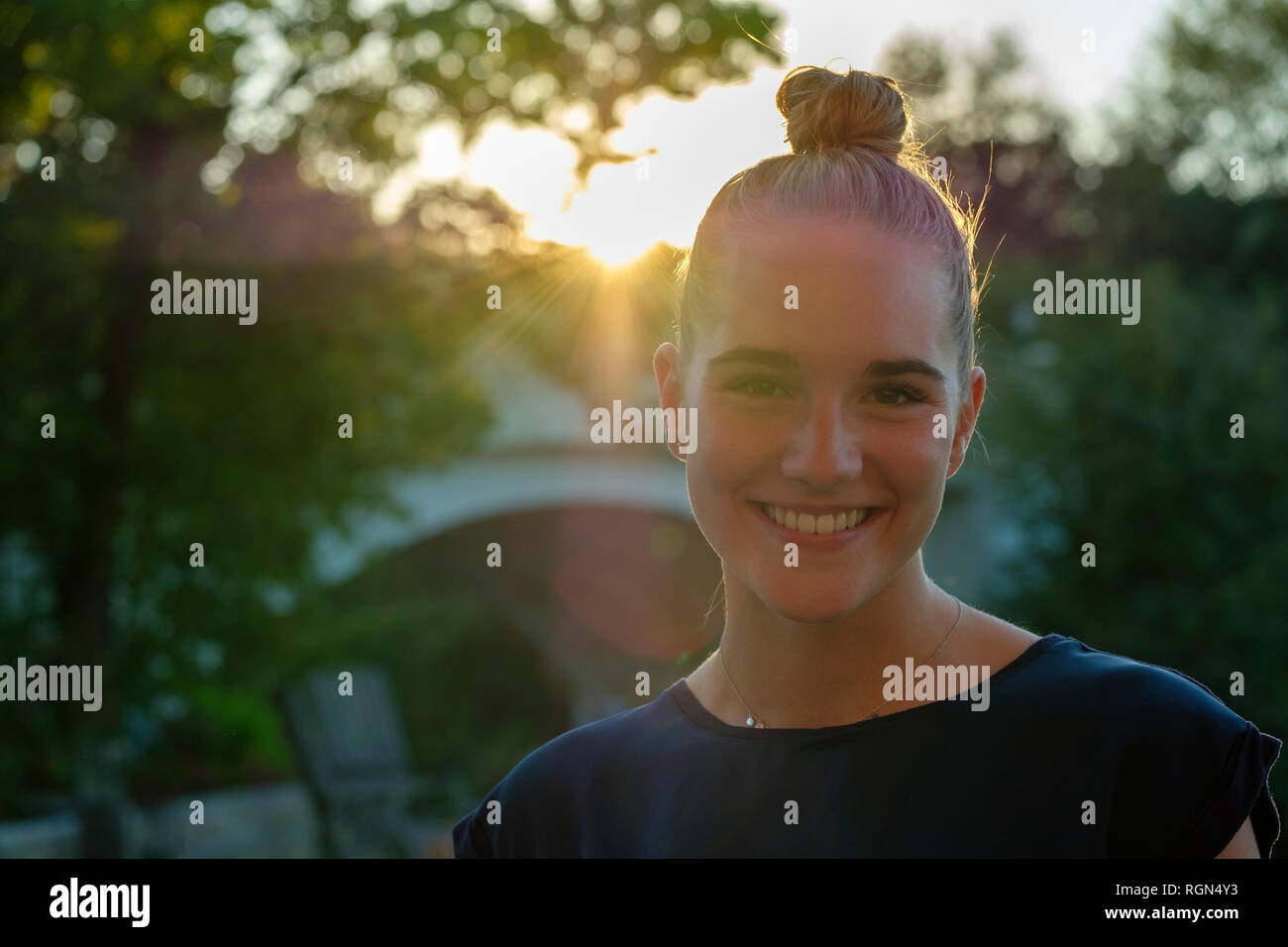 Porträt der jungen Frau mit Brötchen mit Hintergrundbeleuchtung Stockfoto