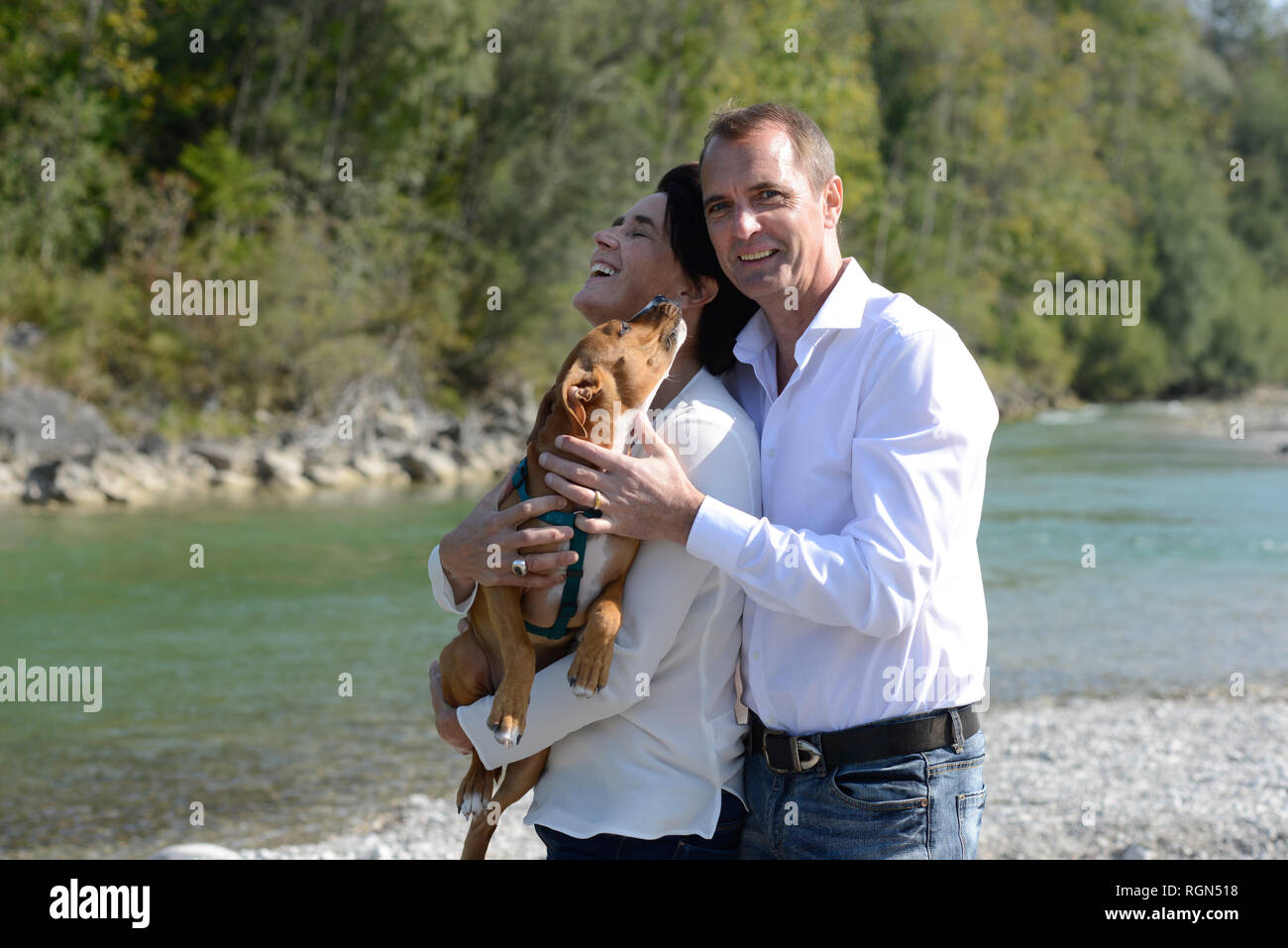 Älteres Ehepaar mit Hund an der Isar, Oberbayern, Deutschland Stockfoto