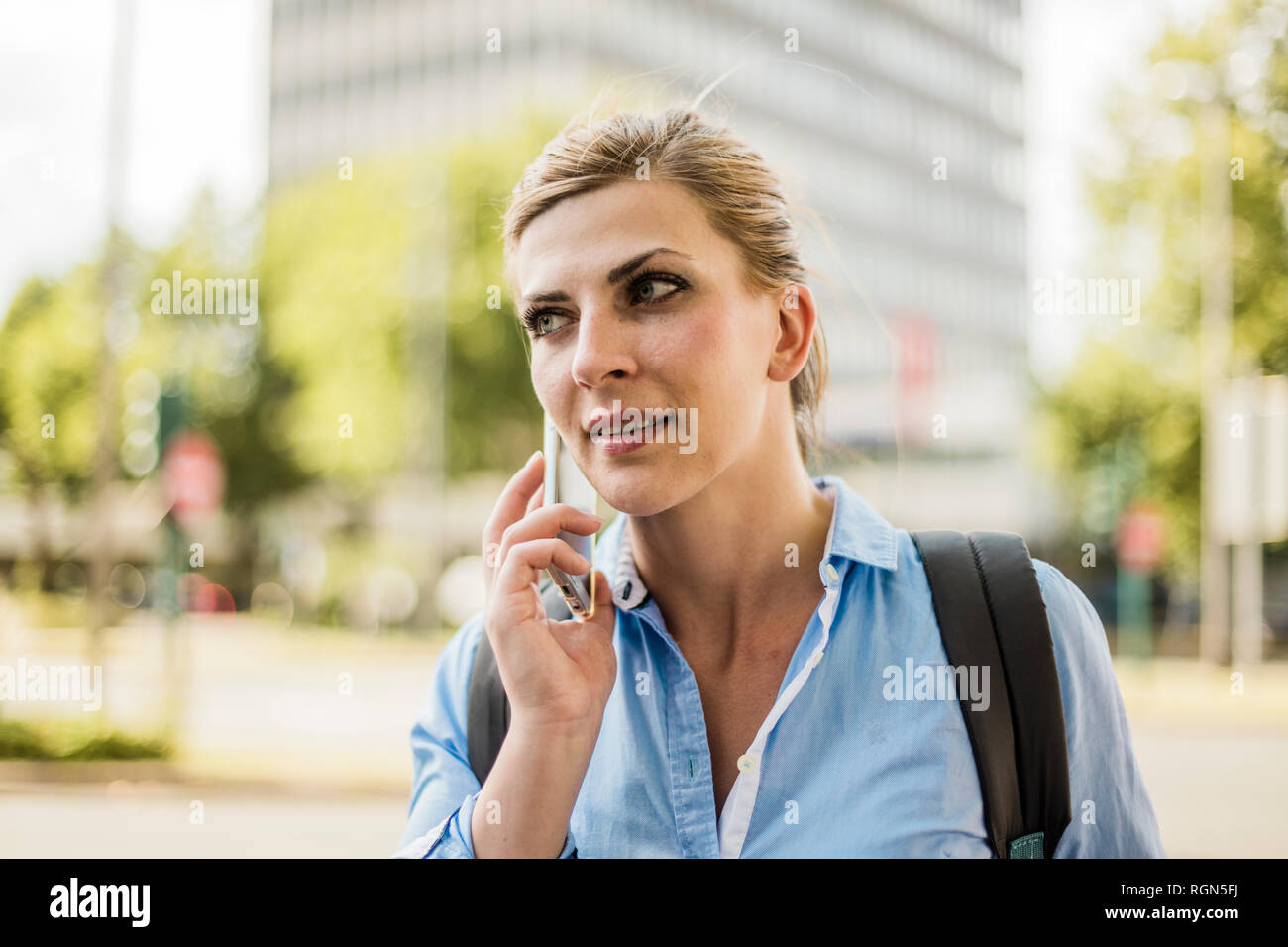 Portrait von Frau mit Rucksack in der Stadt Sprechen über Handy Stockfoto