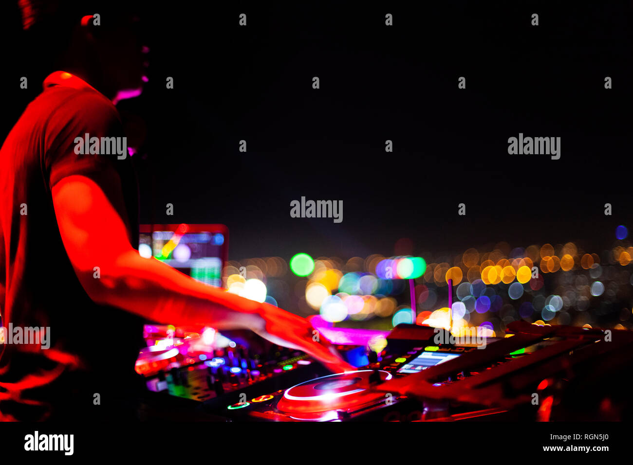 Vietnam, Ho Chi Minh City bei Nacht, DJ im Vordergrund. Stockfoto