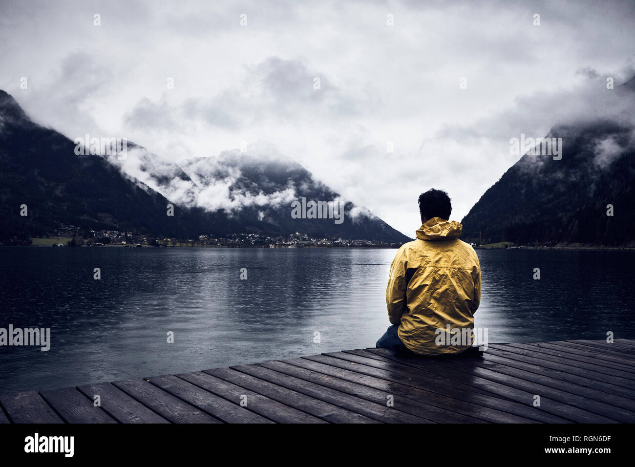 Österreich, Tirol, Achensee, Mann sitzt auf der Promenade Stockfoto