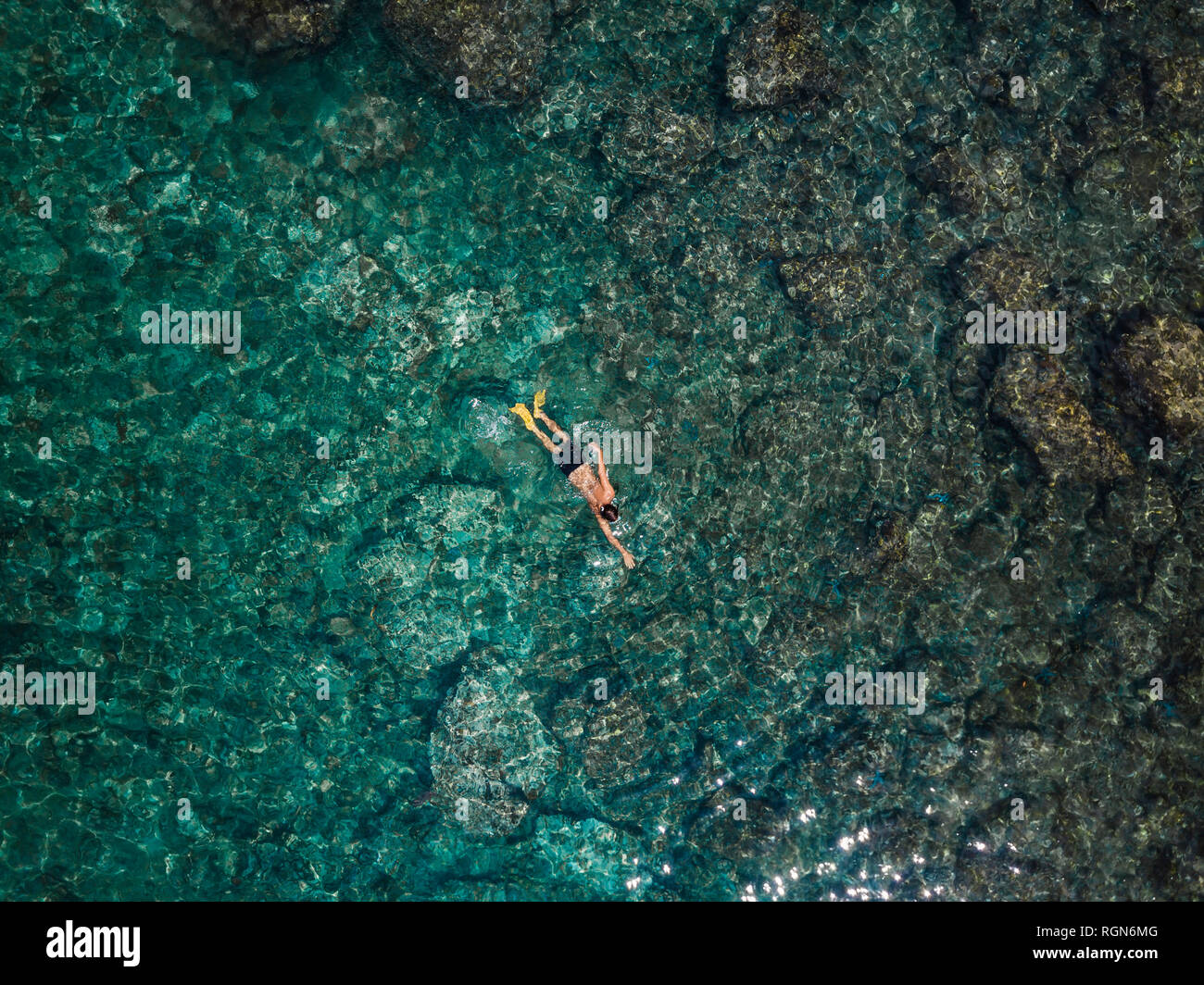 Indonesien, Bali, Mann Schwimmen im Meer am Strand von Amed Stockfoto