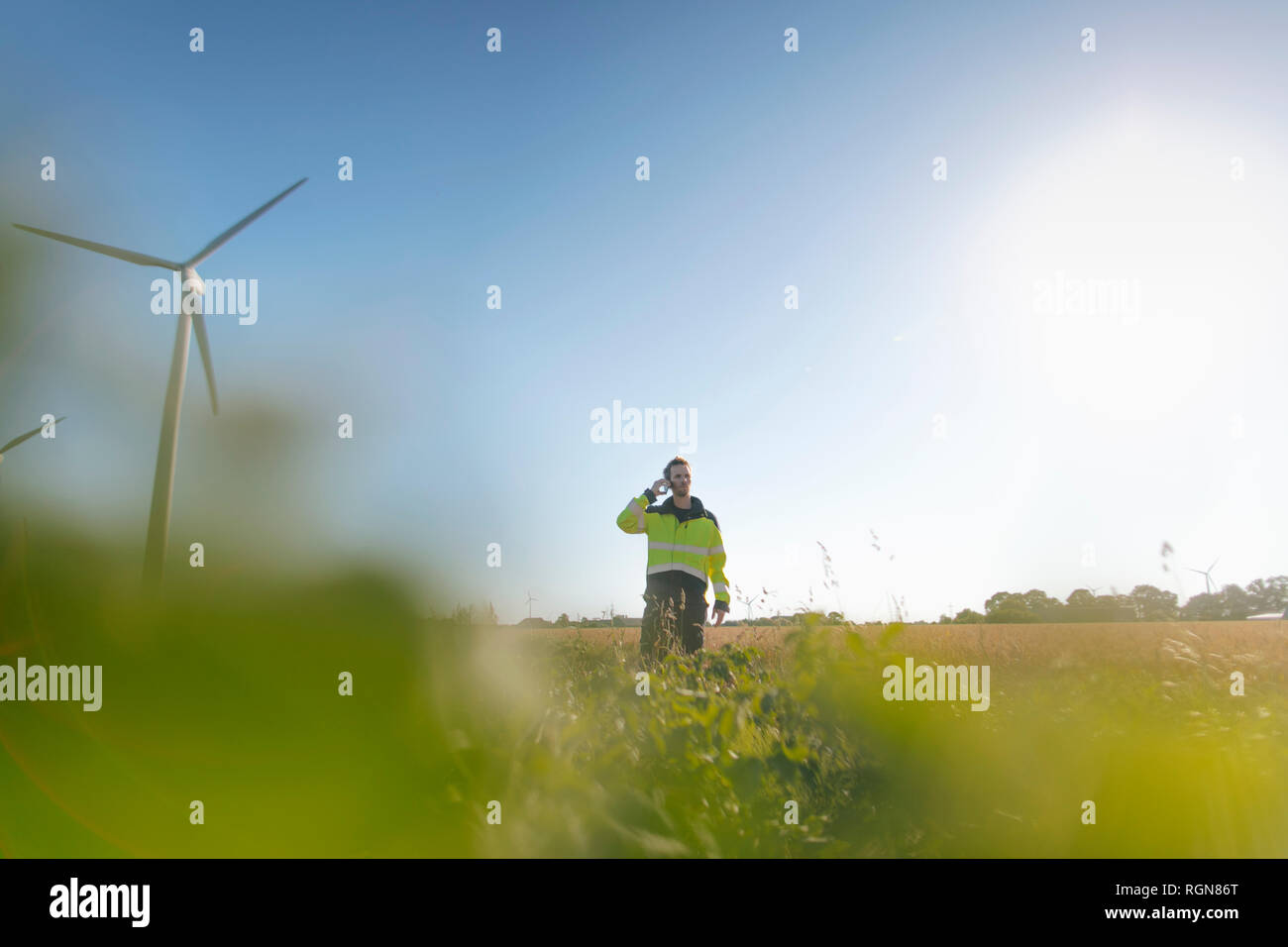 Ingenieur steht ein Feld an einem Windpark Gespräch am Handy Stockfoto