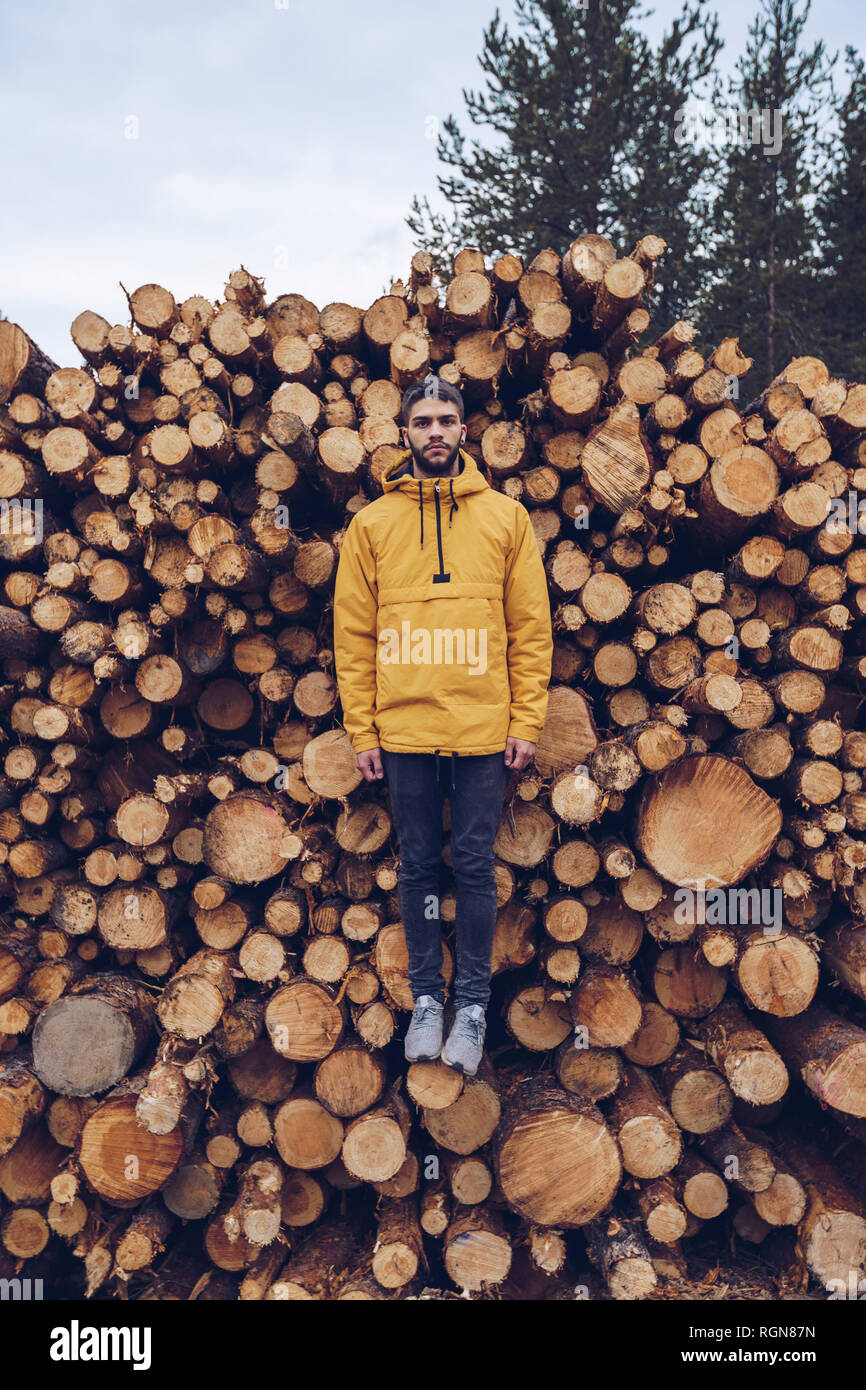 Junger Mann, stehend auf einem Stck Holz, wodurch die Illusion des Schwebens Stockfoto