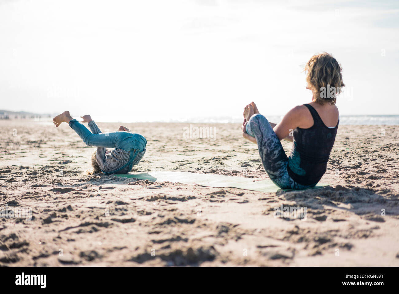 Mutter und Tochter Üben Yoga am Strand Stockfoto
