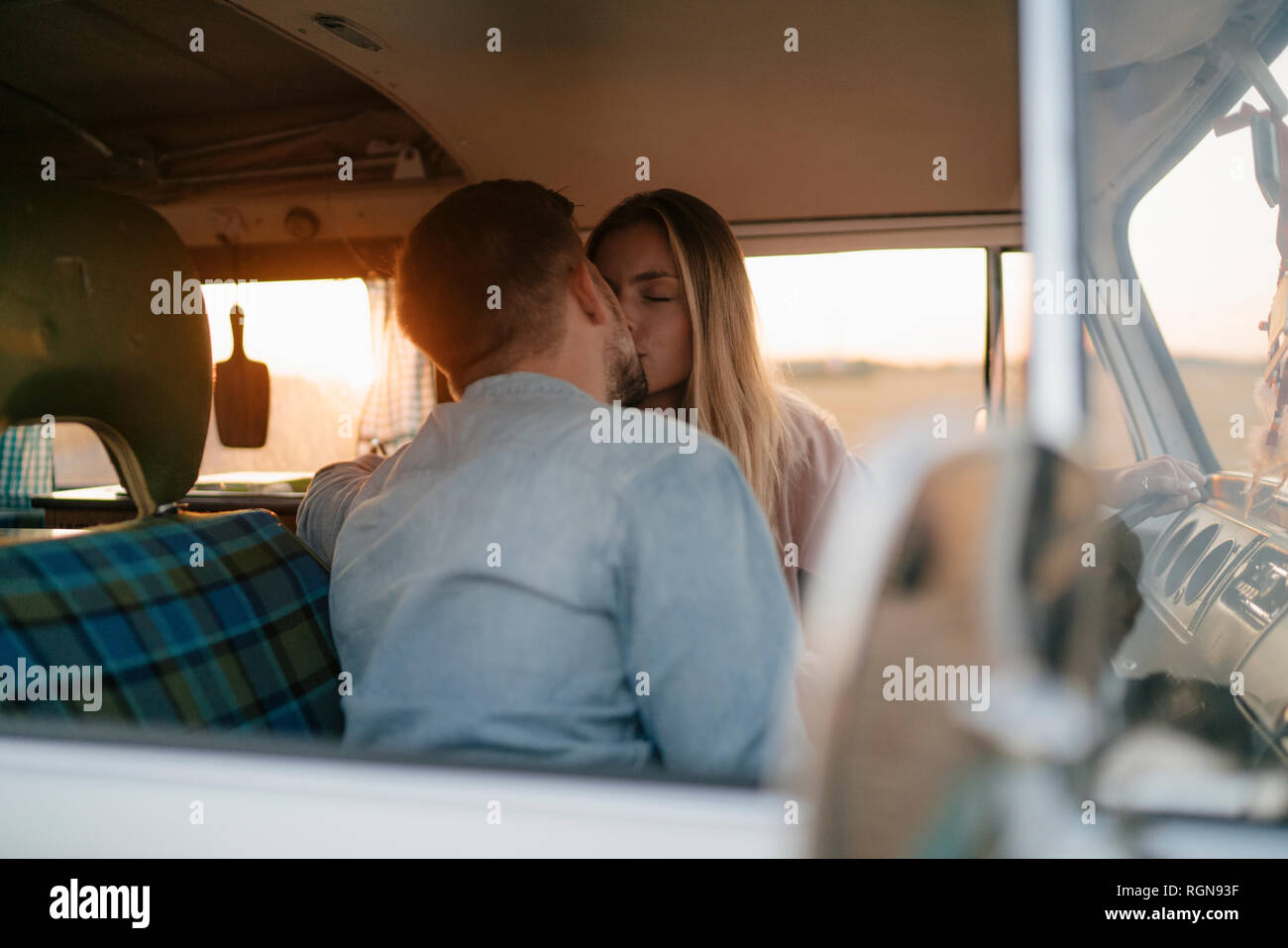 Junges Paar Küssen in Wohnmobil bei Sonnenuntergang Stockfoto