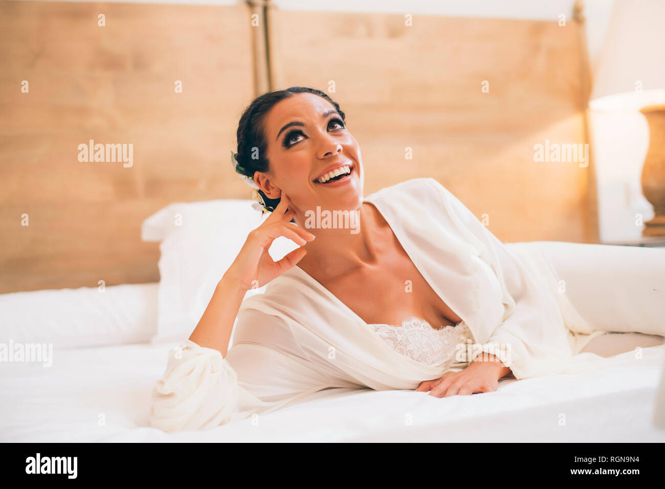 Glückliche Frau liegend auf Bett suchen Stockfoto