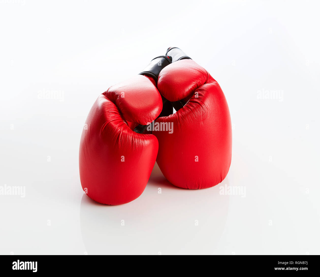 Rote Boxhandschuhe vor weißem Hintergrund Stockfoto