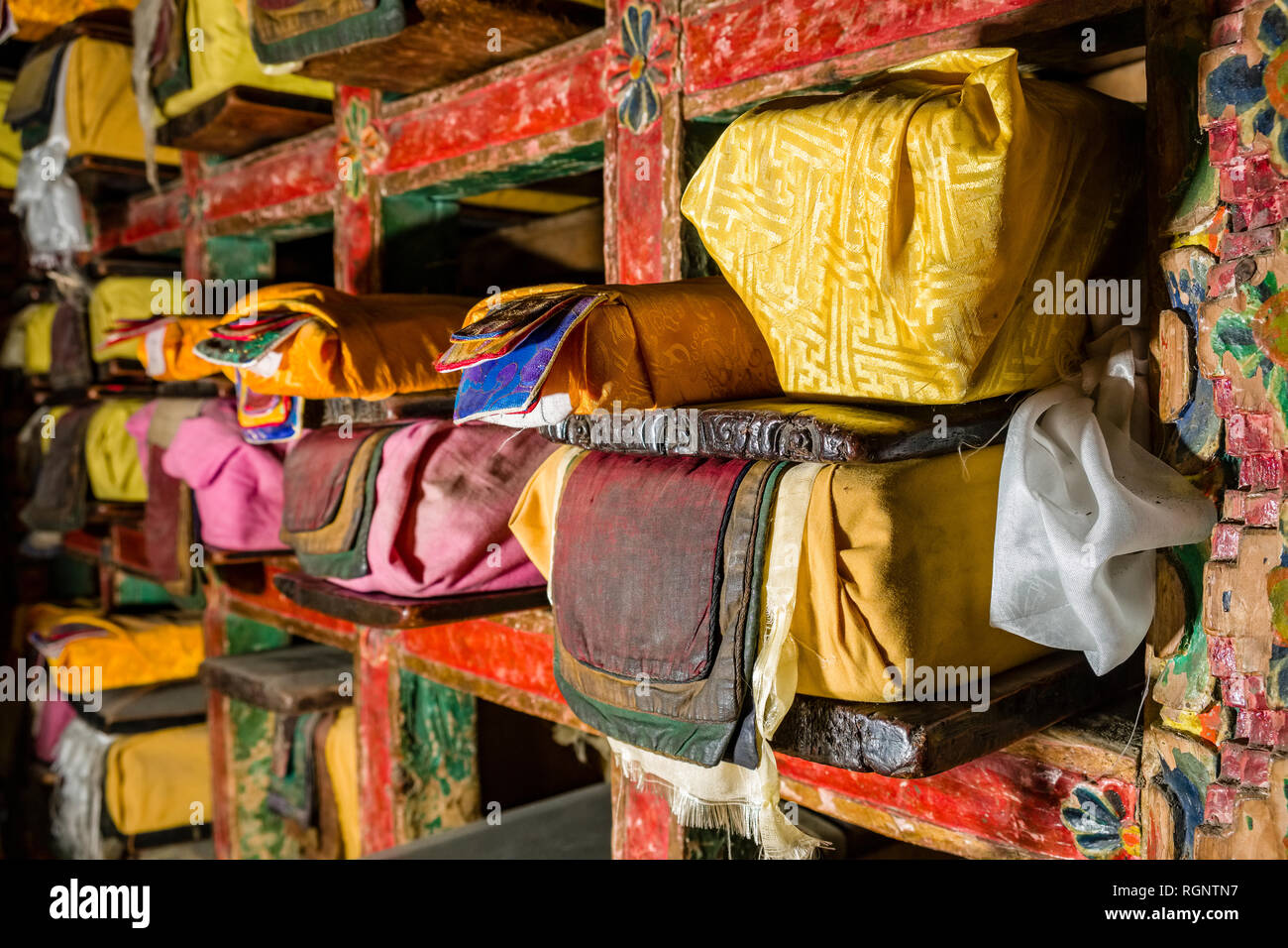 Tibetische Gebetsbücher, in bunten Material verpackt, sind in einem Regal in Braga Gompa, die lokale Kloster gespeichert Stockfoto