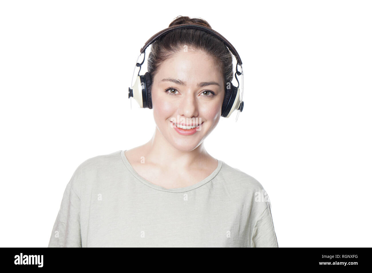 Glückliche junge Frau Abspielen von Musik mit drahtlosen Kopfhörern Stockfoto