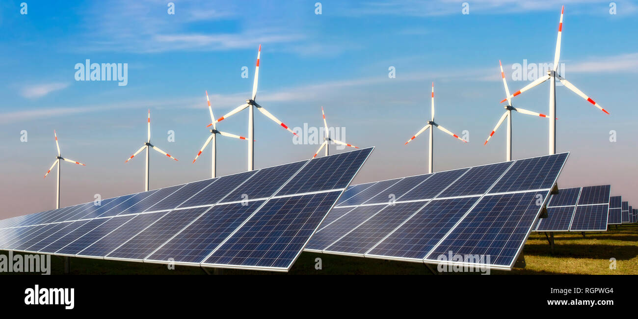 Photovoltaikanlage und Windkraftanlage vor blauem Himmel Stockfoto