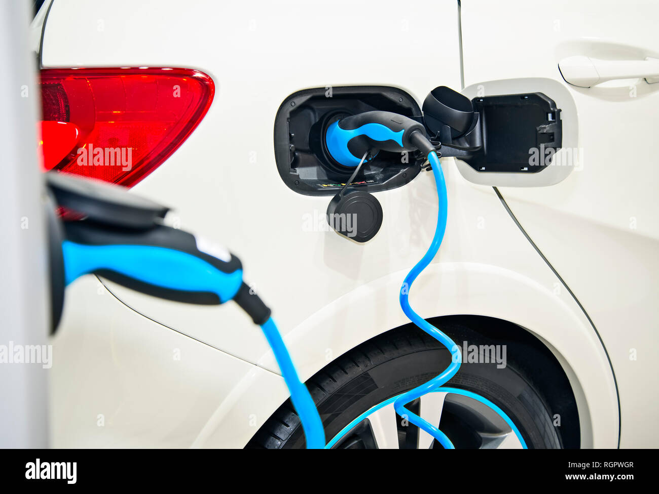 Detail eines Elektroautos mit blauer Stecker Stockfoto