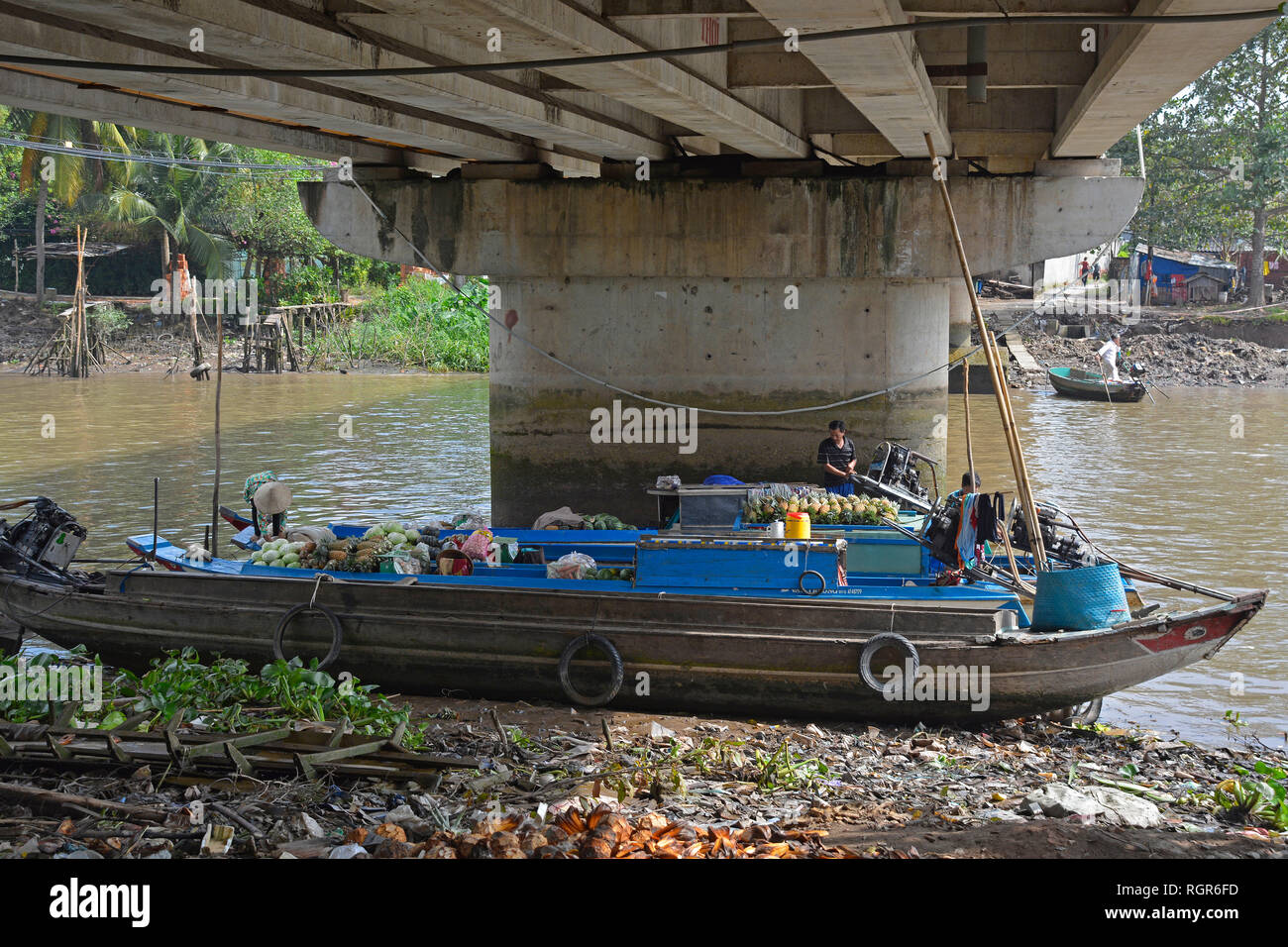 Can Tho, Vietnam - 30. Dezember 2017. Obst Verkäufern auf ihre Boote im Schatten einer Brücke nach Ausgabe der Morgen Verkauf von Obst und Gemüse Stockfoto