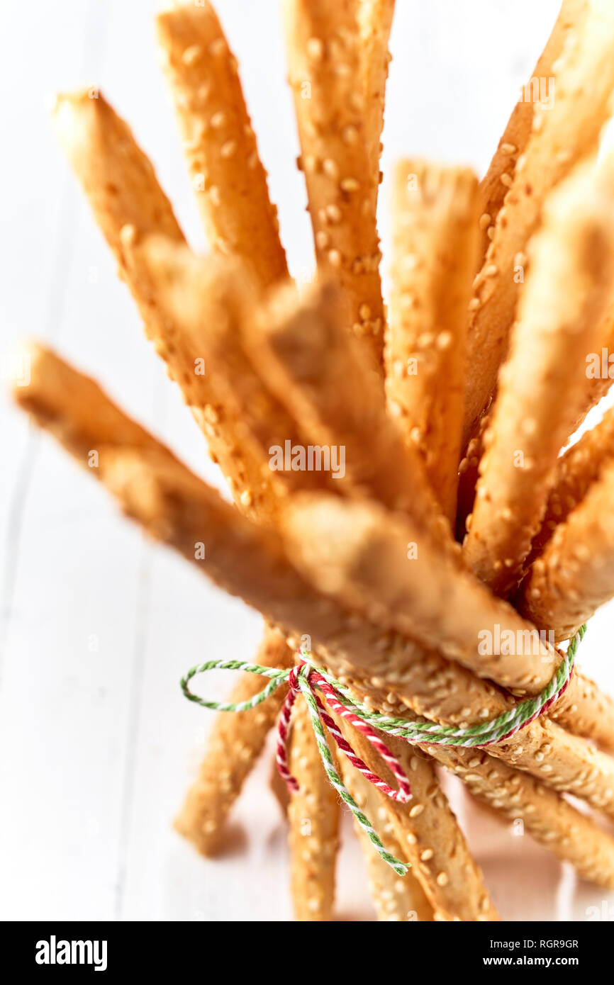 Eine Nahaufnahme von frisch gebackenem Brot, rustikale italienische grissini Sticks mit String gebündelt und Ausgestelltem heraus auf einem high key Holz Hintergrund. Stockfoto