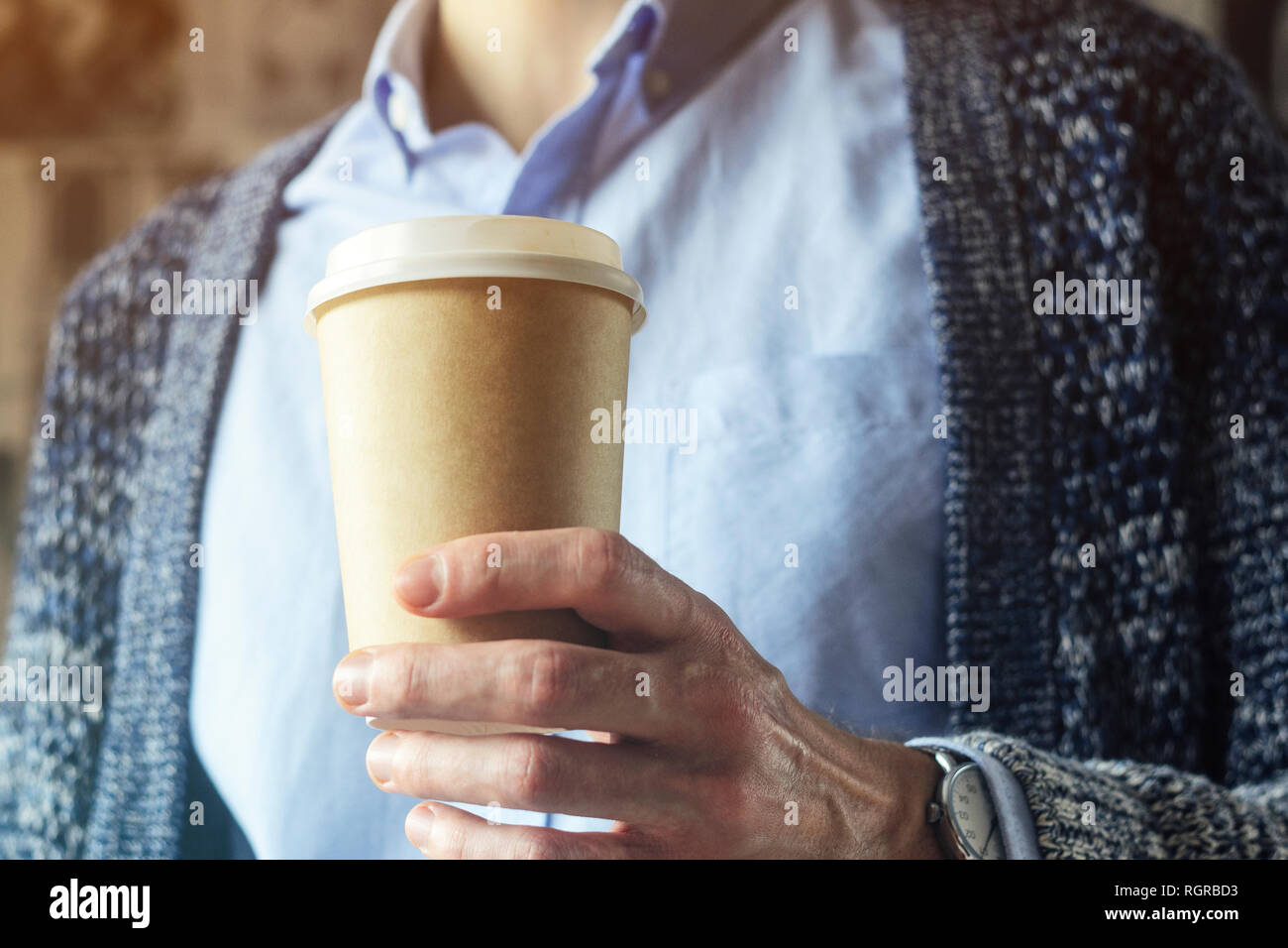 Büro eine Tasse Kaffee. Kaffeepause Hand Pappbecher Strickjacke blaues Hemd. Kaffeepause Konzept Stockfoto