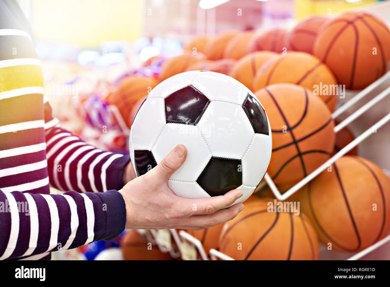 Buyer's Hände mit Fußball und Basketball in der Sport Shop Stockfoto