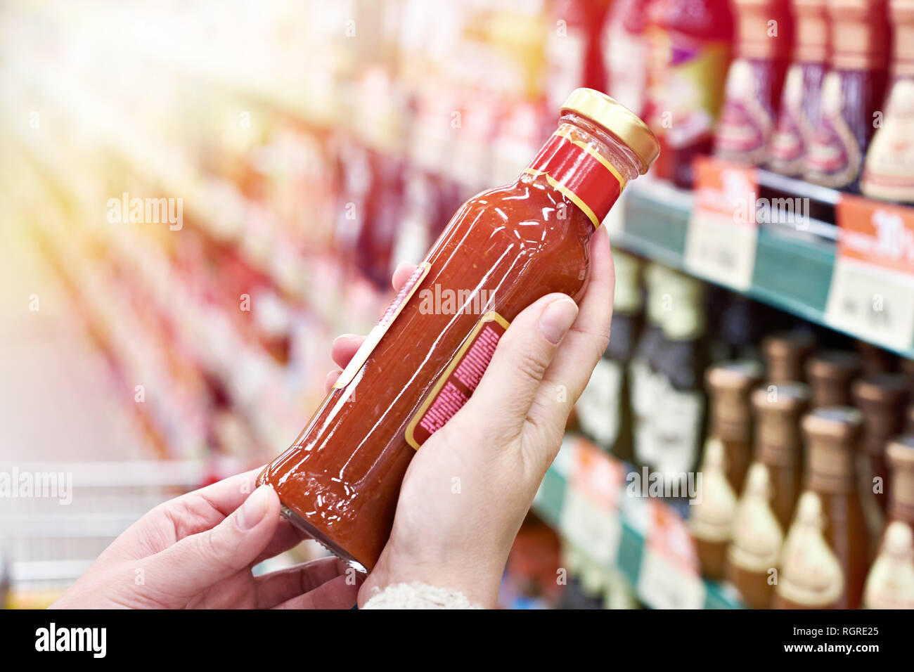 Käufer Hände mit Flasche Chilisauce in Store Stockfoto